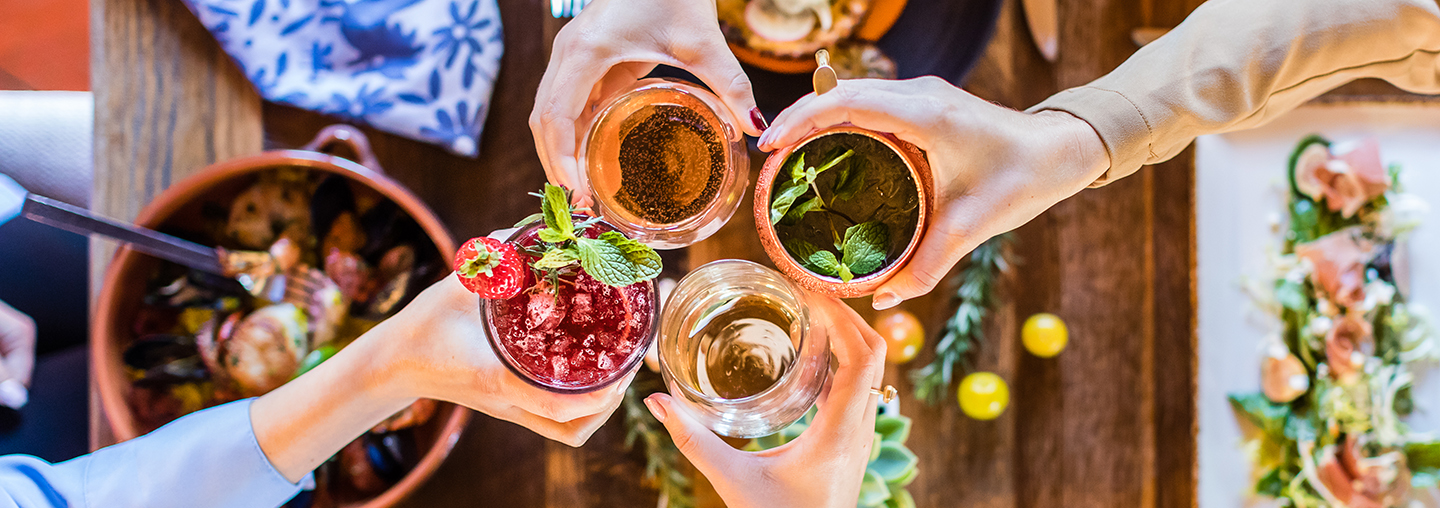 Group cheers with cocktails at restaurant