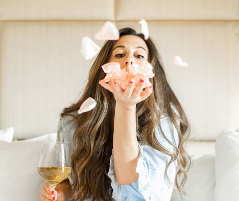 girl blowing rose petals out of hand
